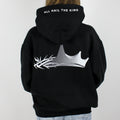 a model wearing a king Jesus oversized hoodie in black. The back design features a crown design that is half a crown of thorns and half a regular crown. There is also text saying "all hail The King".