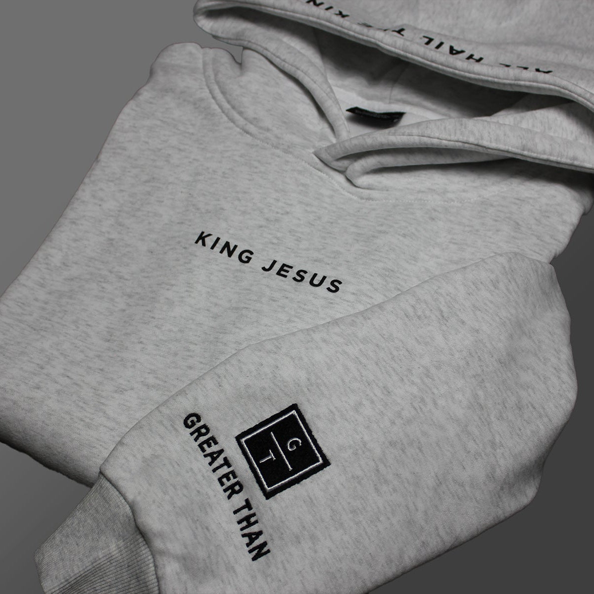 King Jesus hoodie with embroidered design on the wrist of the GREATER THAN Christian Ministries logo